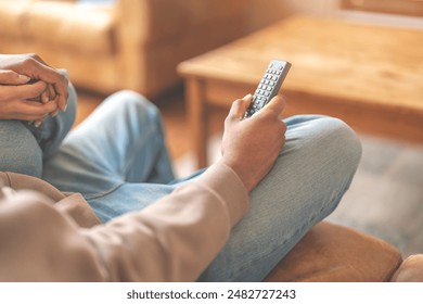 Person Holding Remote Control While Sitting on Couch
