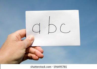 A Person Holding A Sign With The Beginning Of The Alphabet On It.