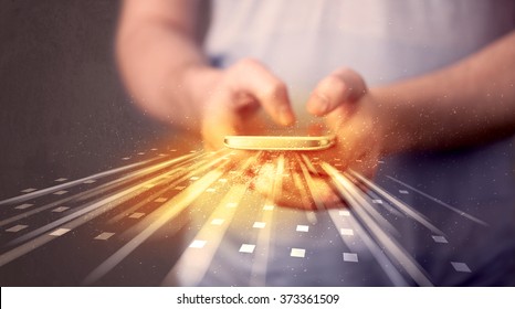 Person holding smarthphone with technology light applications comming out - Powered by Shutterstock