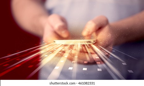 Person holding smarthphone with technology light applications comming out - Powered by Shutterstock