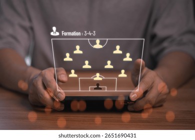 Person holding a smartphone displaying a virtual soccer formation 3-4-3 with player icons. This concept represents strategy planning, team management, and digital sports analytics in modern football. - Powered by Shutterstock - Get 15% off with code: PIKWIZARD15