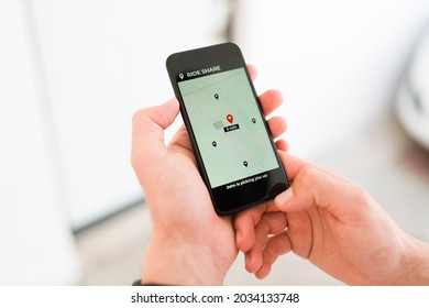 Person Holding A Smartphone While Waiting For His Driver And Looking At The Navigation Map On The Ride Share App 