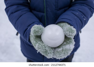 person holding a snowball, hands with snowball, snowball