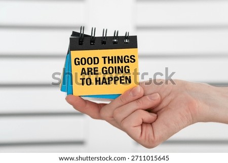 A person is holding a stack of sticky notes with the words Good Things Are Going to Happen written on them