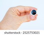 person holding tiny spy surveillance camera, remote monitoring, discrete security solutions, night vision, small size tech gadget, portable, safety