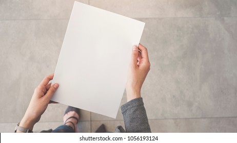Person holding white empty paper - Shutterstock ID 1056193124
