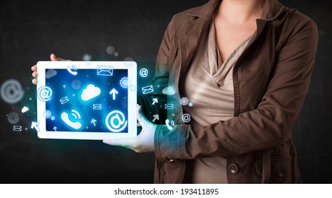 Person holding a white tablet with blue technology icons and symbols - Shutterstock ID 193411895