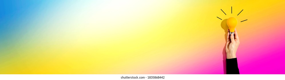 Person Holding A Yellow Light Bulb - Idea And Creativity Theme