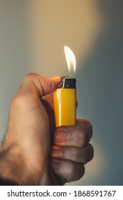 Person Holding A Yellow Lit Lighter