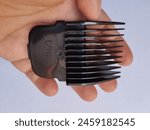A person holds a 12mm hair removal clipper in their hand, showcasing the tool
