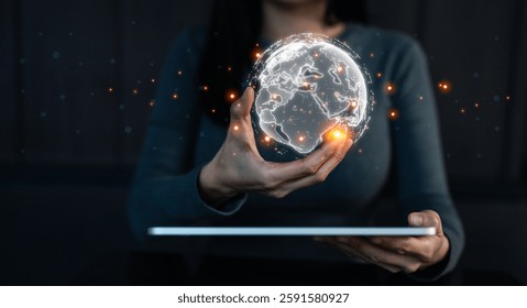 A person holds a glowing globe, symbolizing global connectivity and technology, with a digital tablet in front, showcasing a modern, tech-savvy environment.