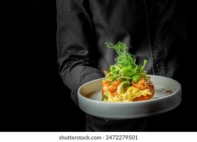 A person holds a plate with gourmet shrimp on creamy risotto, garnished with greens - Powered by Shutterstock