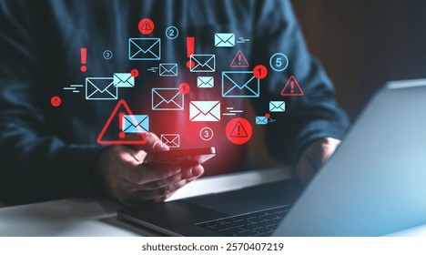 Person holds smartphone with alert icons and email symbols, glowing on dark background, representing spam, notifications, and digital communication