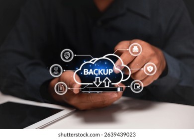 A person holds a smartphone displaying a digital cloud backup interface with various data icons, symbolizing data storage and cloud computing. - Powered by Shutterstock - Get 15% off with code: PIKWIZARD15