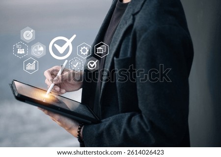A person holds a tablet while using a stylus, with floating icons around them including a checkmark, chart, gear, and globe—symbolizing digital approval, analysis, and global access.