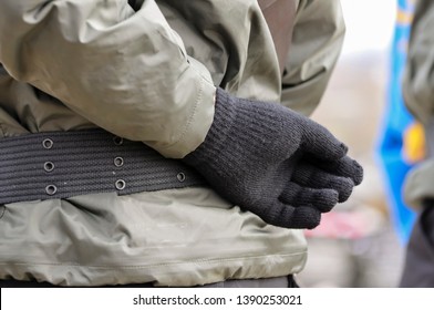 A Person Holds Their Gloved Hand Behind Their Back As They Wear A Paramilitary Uniform