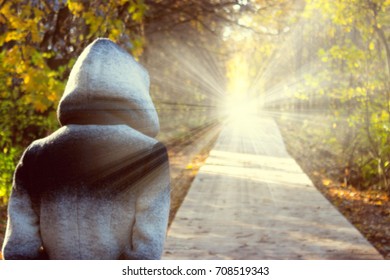 Person In A Hood Walking Toward The Light. Lidht In The End Of The Tunnel. Clinical Death Concept