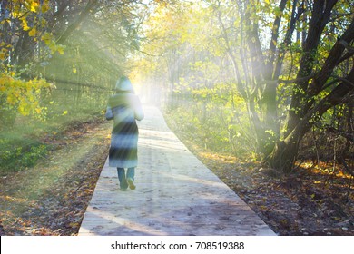 Person In A Hood Walking Toward The Light. Lidht In The End Of The Tunnel. Clinical Death Concept