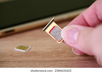 Person inserting a sim card into back of mobile phone, Sim card in tray being inserted into phone, closeup