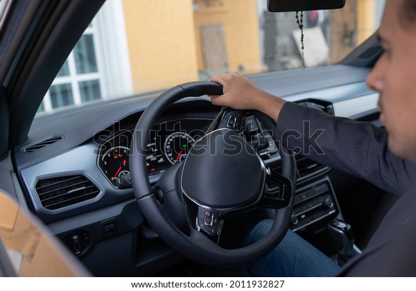 a\
person inside a nice car holding the steering\
wheel