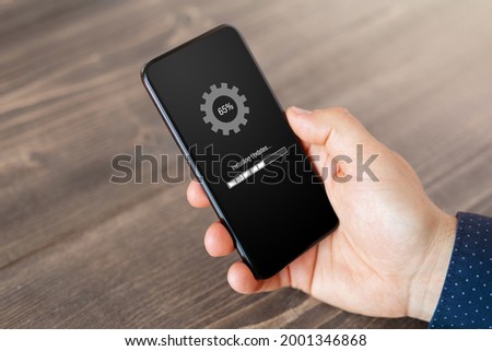 Person installing software updates on mobile phone