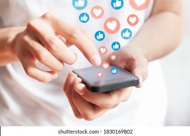 Person interacting on social media network with smartphone by liking and loving posts. Advertising on mobile phone by collecting user data and targeting profiles - Powered by Shutterstock