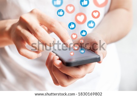 Person interacting on social media network with smartphone by liking and loving posts. Advertising on mobile phone by collecting user data and targeting profiles