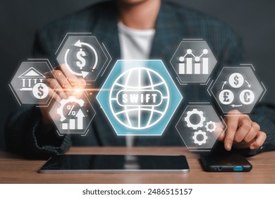 A person interacts with a digital interface displaying financial icons and the word "SWIFT," symbolizing modern business and technology solutions. - Powered by Shutterstock