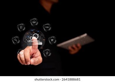A person interacts with a digital interface showing a globe and "UPDATING" status, surrounded by technology icons, while holding a tablet.