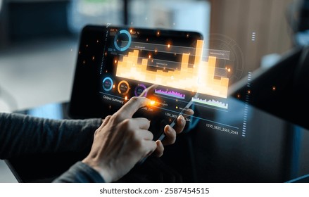 A person interacts with a digital tablet displaying vibrant data visualizations and analytics in a modern workspace.