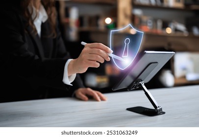 A person interacts with a digital tablet, using a stylus to engage with a virtual shield icon. Represents cybersecurity, data protection, and secure technology for modern devices
