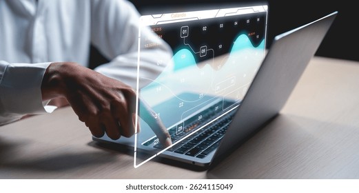 A person interacts with futuristic data analytics displayed as a holographic interface above a laptop.