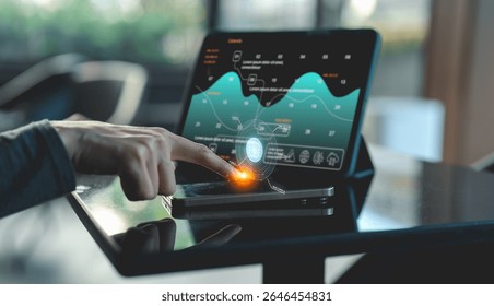 A person interacts with a futuristic touchscreen displaying data analytics and charts on a tablet with holographic interface elements in a modern workspace.