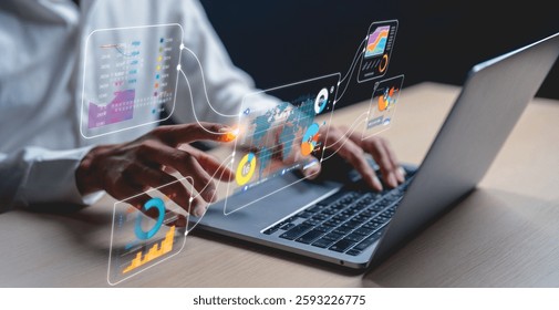 A person interacts with a laptop, exploring digital graphs and analytics in a modern, tech-driven workspace.