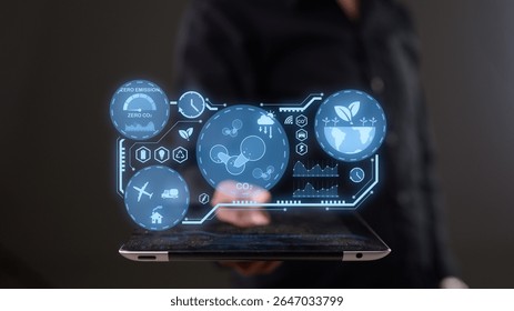 A person interacts with a tablet displaying futuristic, holographic environmental and sustainability data visuals.