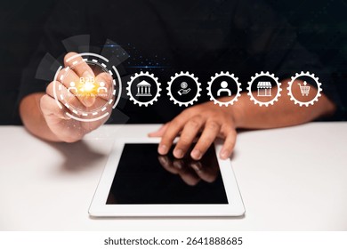 A person interacts with a tablet using futuristic digital icons representing business and commerce concepts like B2B, shopping, and user profiles.