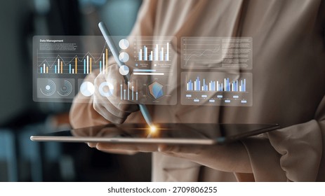 A person interacts with a tablet, utilizing digital tools for data management. Virtual charts and graphs illustrate real-time performance analysis and insights. Gantry