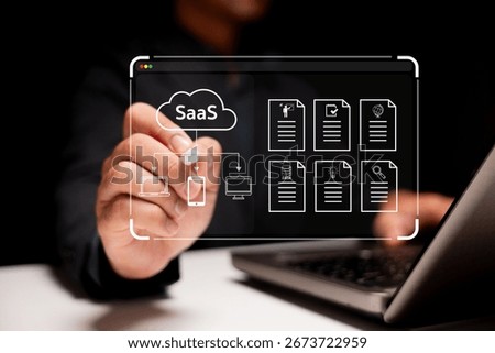 A person interacts with a virtual interface showcasing SaaS solutions and document management on a laptop in a dark setting.