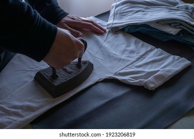 Person Ironing With Old Iron On Wrinkled Clothes