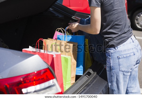 Person keeping\
shopping bags inside the\
car
