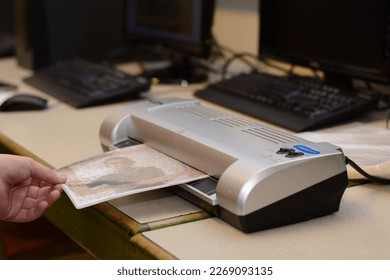 Person laminated a printed image - Shutterstock ID 2269093135