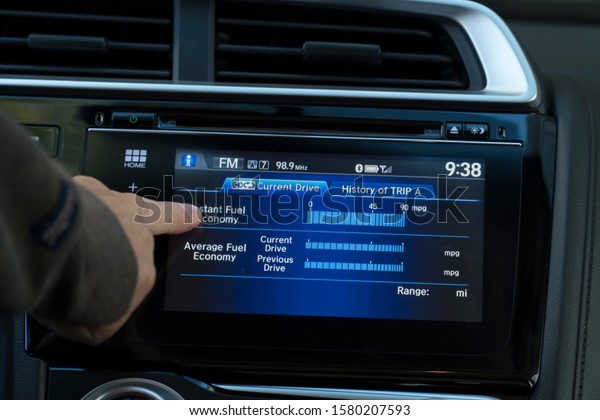 Person is learning the\
touch screen in a car to inspect performance and can be used for\
entertainment .