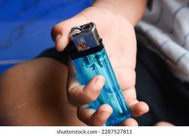A person lighting a blue match. The hand is holding a lighter