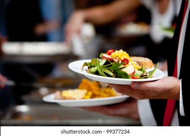 a person in line with their food during a banquet or other catered event