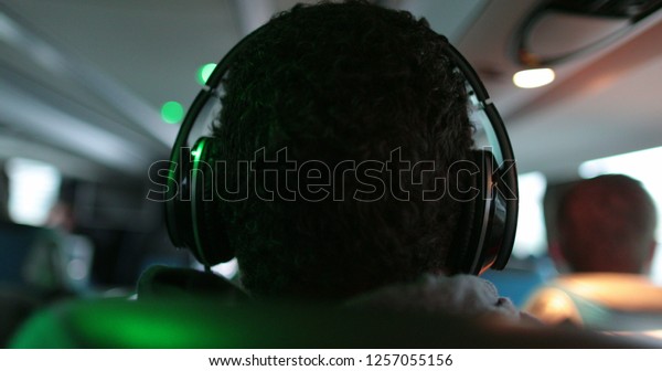 Person listening to music with headphones while\
traveling by bus