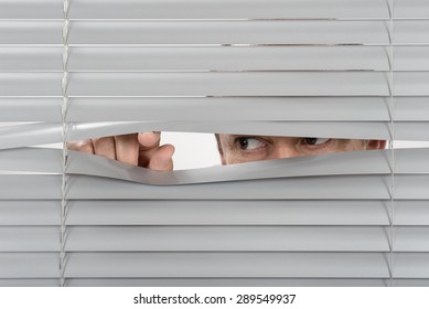 Person looking behind window jalousie