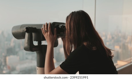 Person looking in binoculars telescope on observation deck for tourist. Tower sky viewpoint top floor. City skyline panorama at day time. Travel, tourism, outdoor lifestyle holiday vacation. Back view - Powered by Shutterstock