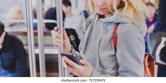 person looking at the screen of smart phone in subway, woman holding mobile in metro