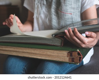 Person Is Looking Through Family Photo Album To Engage In A Memory. Concept Of Fond Memories