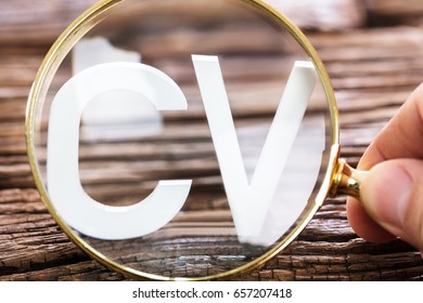 A Person Looking At White CV Word Through Magnifying Glass